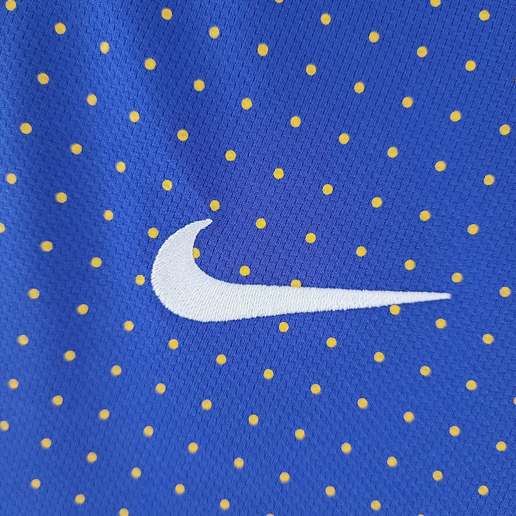 Camisola Brasil Away 2010 Retro com padrão azul e amarelo, logo Nike em destaque. Camisola Brasil para fãs de futebol.