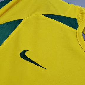 Camisola Brasil Home 2002 Retro com detalhes em verde e logo da Nike em preto.