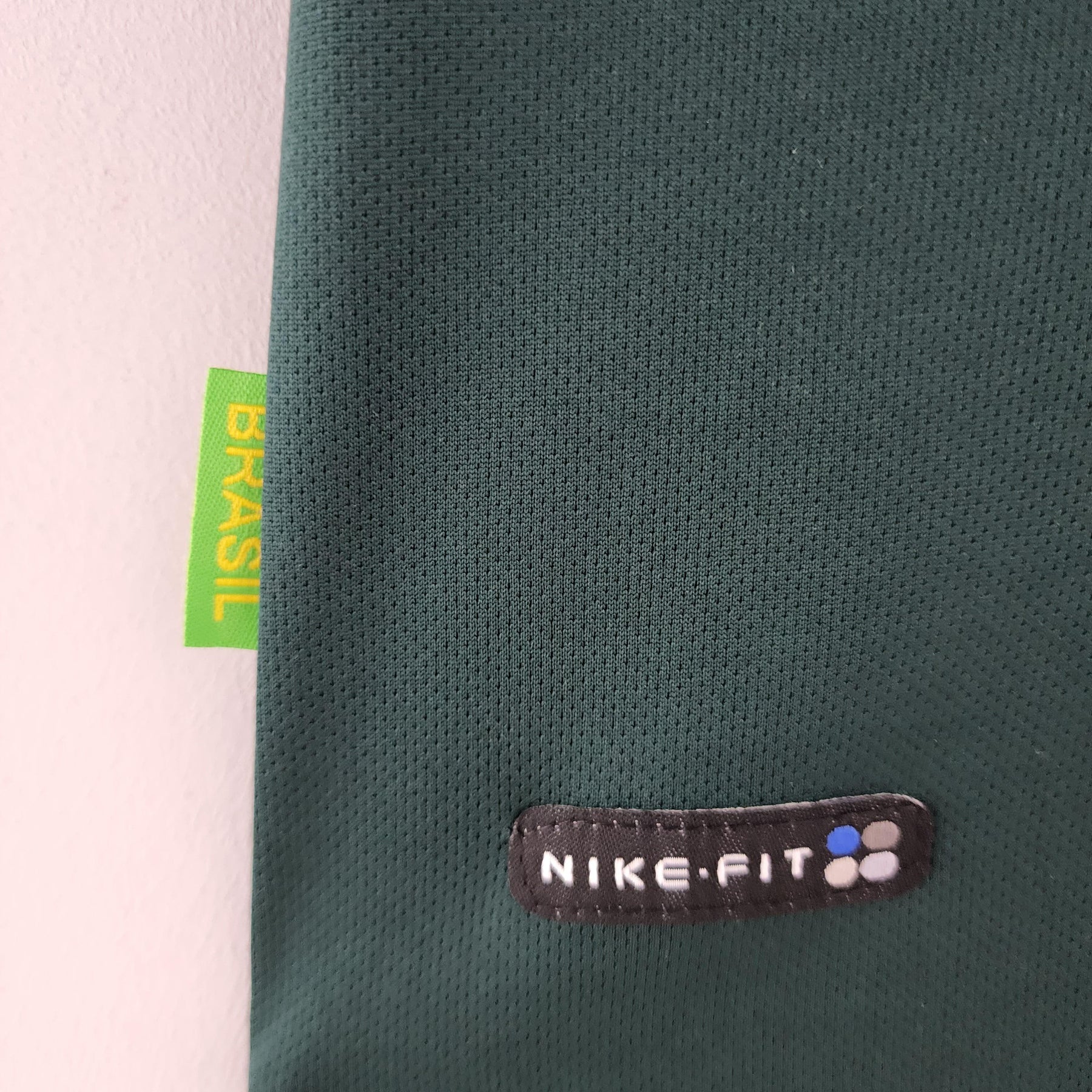 Detalhe da camisola Brasil Home 98/99 Retro com logo Nike-fit e etiqueta verde "BRASIL".