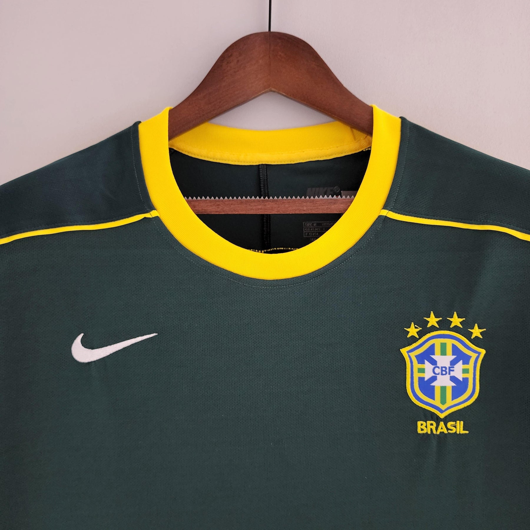 Camisola Brasil Home 98/99 Retro, detalhe do colarinho e logo da seleção, com estampa em amarelo e azul.