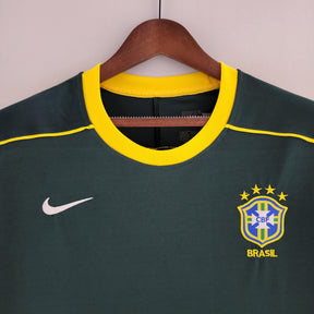 Camisola Brasil Home 98/99 Retro, detalhe do colarinho e logo da seleção, com estampa em amarelo e azul.
