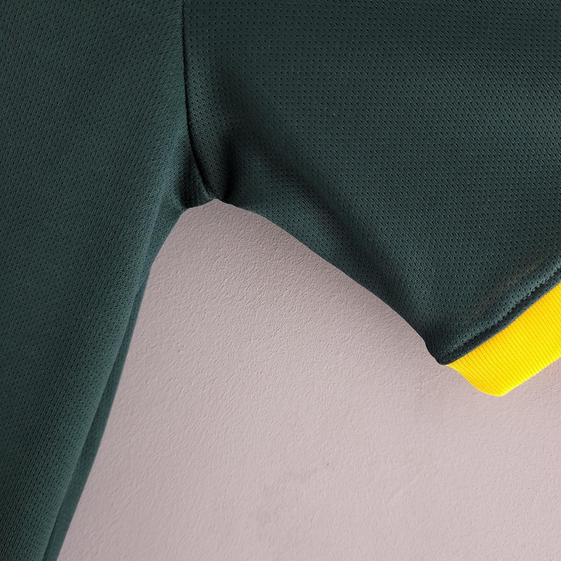 Detalhe da manga da Camisola Brasil Home 98/99 Retro, destacando a cor verde e detalhes em amarelo.