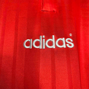 Detalhe da logo adidas em tecido vermelho da camisola Espanha GK 1994 Retro.