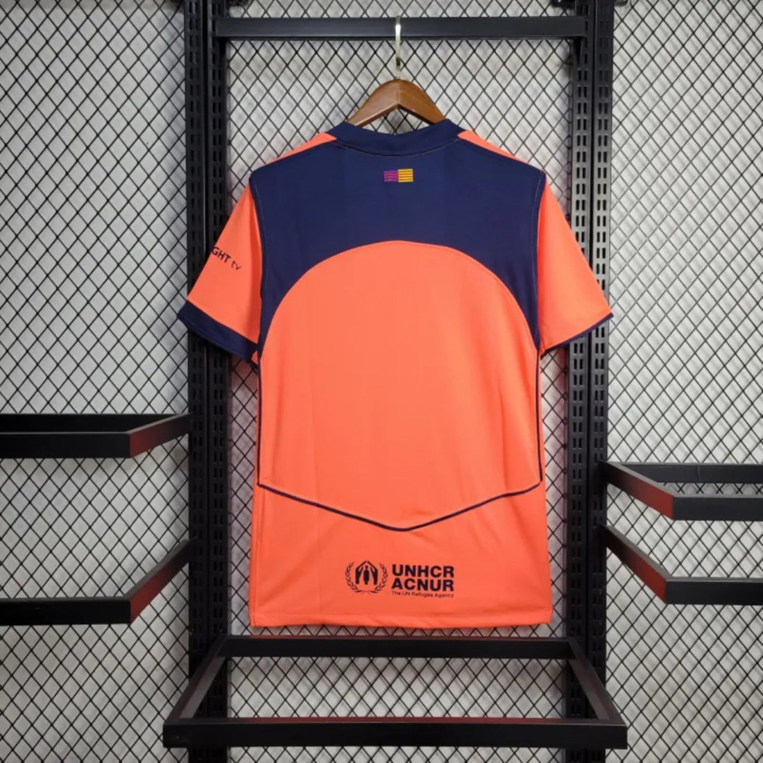 Camisola FC Barcelona third laranja 2025/26 - TOTAL 90, vista traseira em exposição, com logo UNHCR ACNUR.