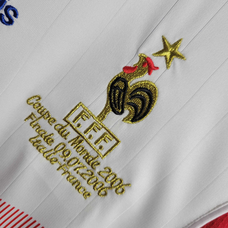Camisola França 2006 Retro, detalhe do emblema bordado com galo e data da final da Copa do Mundo.