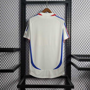 Camisola França away 2006 Retro, vista traseira em fundo neutro, destaque para as cores azul e vermelho.