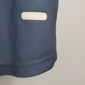 Detalhe da camisa PSG Away 01/02 Retro Azul Olympic, destacando a etiqueta ORI-FIT na parte inferior.