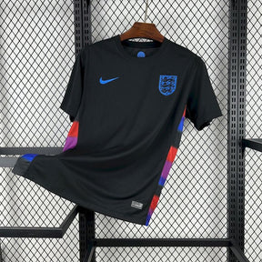 Camisola Inglaterra edição especial 25/26 da OLYMPIC STORE em fundo preto, com design moderno e logo da seleção inglesa.