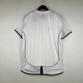 Camisola Inglaterra home 2002 Retro vista traseira em estilo branco com detalhes em azul e vermelho.