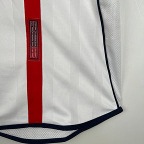 Camisola Inglaterra home 2002 Retro detalhes, mostrando a faixa vermelha e o logo na camiseta.