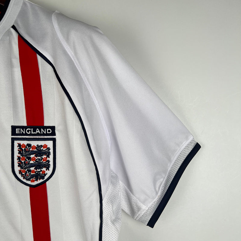 Camisola Inglaterra home 2002 Retro com detalhes em vermelho e brasão da Inglaterra.