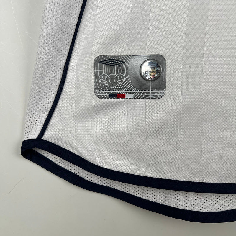 Camisola Inglaterra home 2002 Retro com logotipo da Umbro e detalhes em azul.