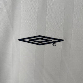 Logo Umbro em camisola Inglaterra home 2002 Retro, destacando design clássico e estilo icônico.