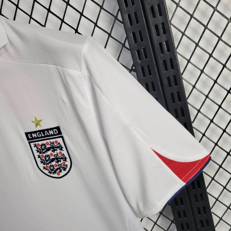 Camisola Inglaterra home 2005 Retro com escudo e detalhes da camisa em fundo preto.