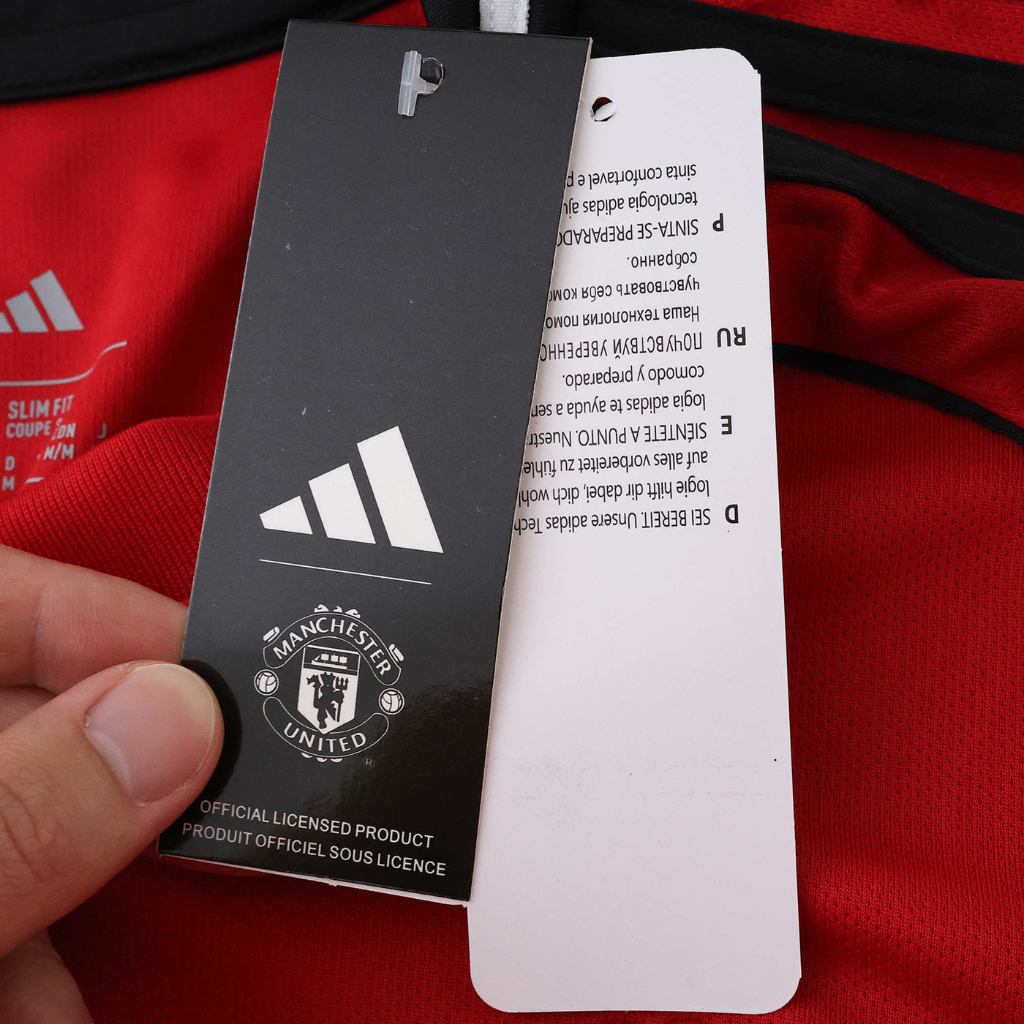 Etiqueta da camisola Manchester United Home 2025/26 com logo Adidas e informações do produto.