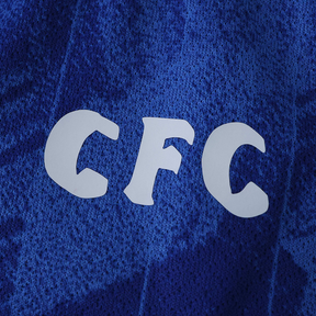 Detalhe da Camisola Chelsea Home 2025/26 com logo CFC em destaque, ideal para torcedores do Chelsea.