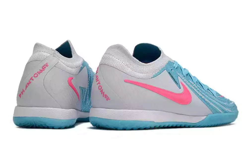 Chuteira Futsal Nike Phantom GX II IC Azul, Branca e Rosa modelo traseiro com detalhes em rosa e azul.