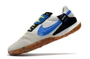 Chuteira Futsal Nike Street Gato IC Bege e Azul em salto com design moderno e cores vibrantes.