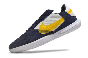Chuteira Futsal Nike Street Gato IC - Branca, Azul e Amarela em ângulo lateral, destacando design e cores vibrantes.