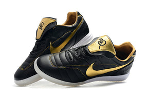 Chuteira Futsal Tiempo Legend Elite IC "Ronaldinho" Preta com detalhes em dourado e sola branca para melhor desempenho em quadra.