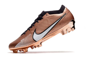Chuteira Nike Air Zoom Mercurial Vapor 15 Elite FG em tom de bronze com detalhes em prata para desempenho em campo.