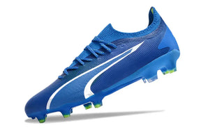 Chuteira Puma Ultra Ultimate FG Azul em azul com detalhes em branco e sola verde, ideal para desempenho em campo.