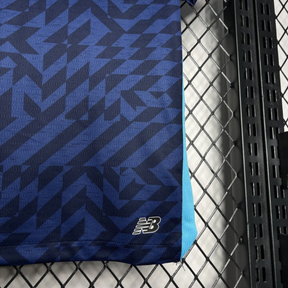 Conjunto infantil FC Porto azul terceiro equipamento 2024/25, detalhe do tecido e logotipo da New Balance.