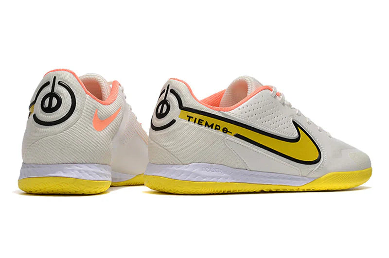 Chuteira Futsal Nike Tiempo Legend 9 Elite IC Branco com detalhes em amarelo e rosa.