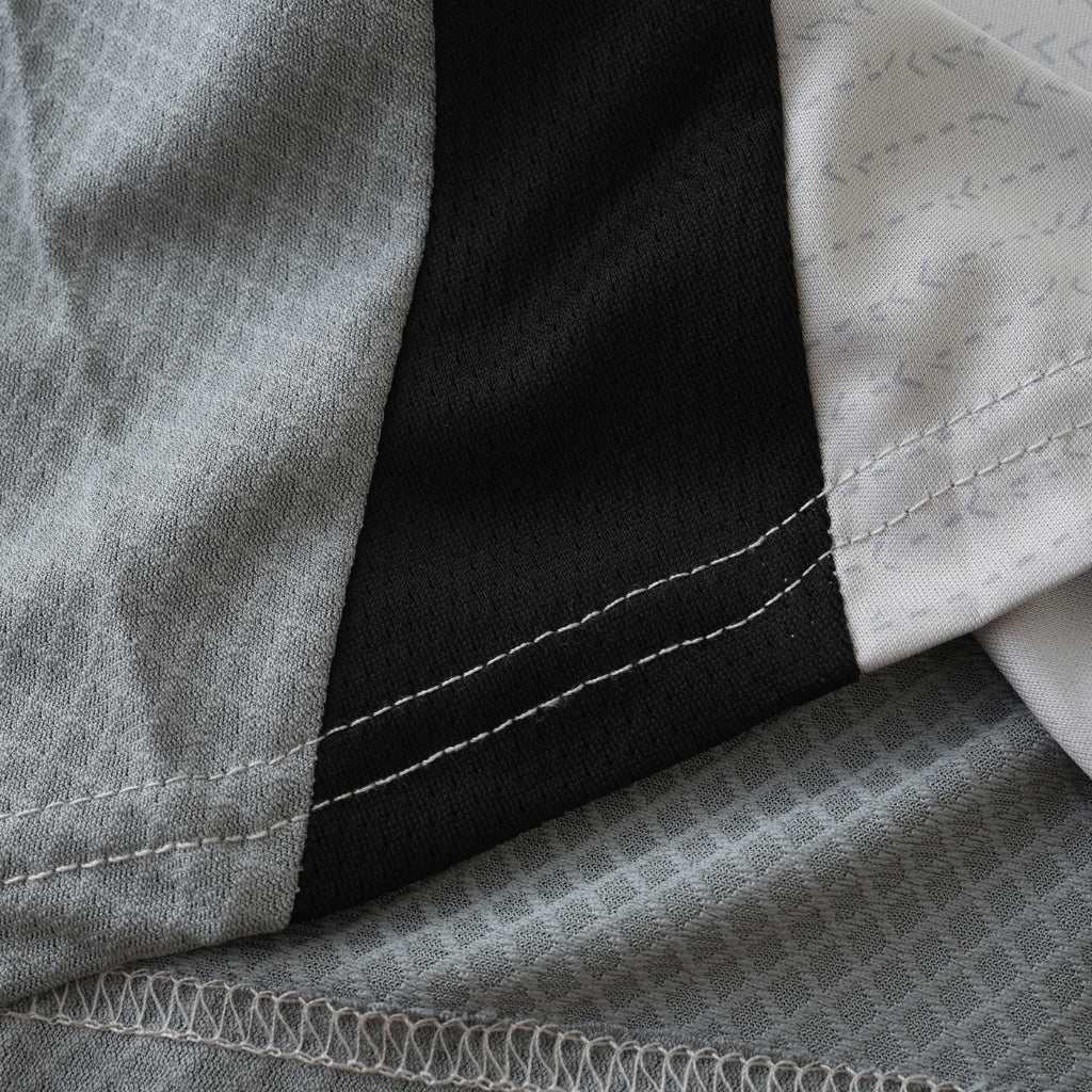 Detalhe da Camisola Benfica Third 2024/25 com costuras e tecido em cores variáveis.