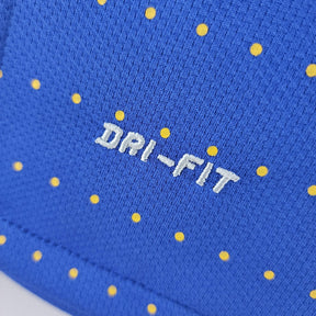 Detalhe da textura e estampa da camisola Brasil, destacando a tecnologia DRI-FIT em azul com bolinhas amarelas.