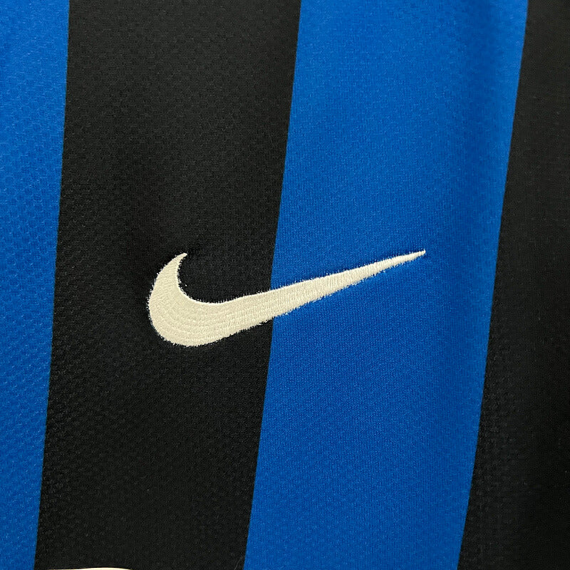 Logo da Nike em um uniforme Inter de Milão Jersey Home 09/10 Retro, com listras azuis e pretas.