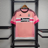 Camiseta Juventus Away 15/16 Retro cor rosa, com logo Jeep e detalhes em preto, pendurada em exibição.