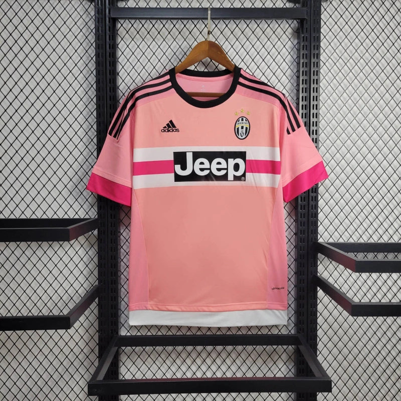 Camiseta Juventus Away 15/16 Retro cor rosa, com logo Jeep e detalhes em preto, pendurada em exibição.