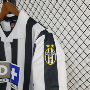 Camisa Juventus Home 98/99 Retro com detalhes em preto e branco e logo da Juventus na manga.