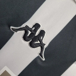 Logotipo da Kappa em detalhe na Juventus Home Jersey 98/99 Retro, com listras brancas e pretas.