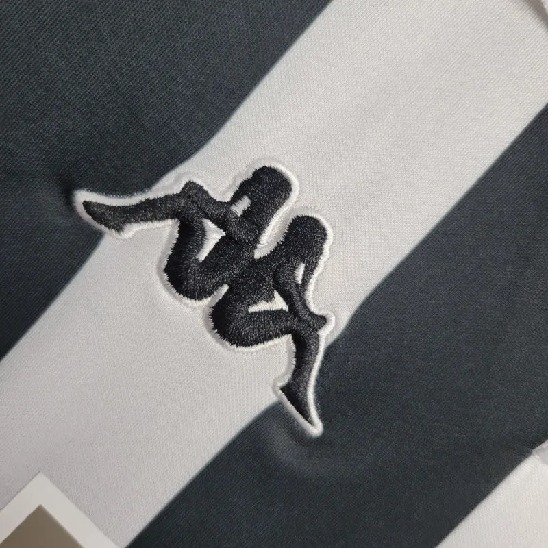 Logotipo da Kappa em detalhe na Juventus Home Jersey 98/99 Retro, com listras brancas e pretas.