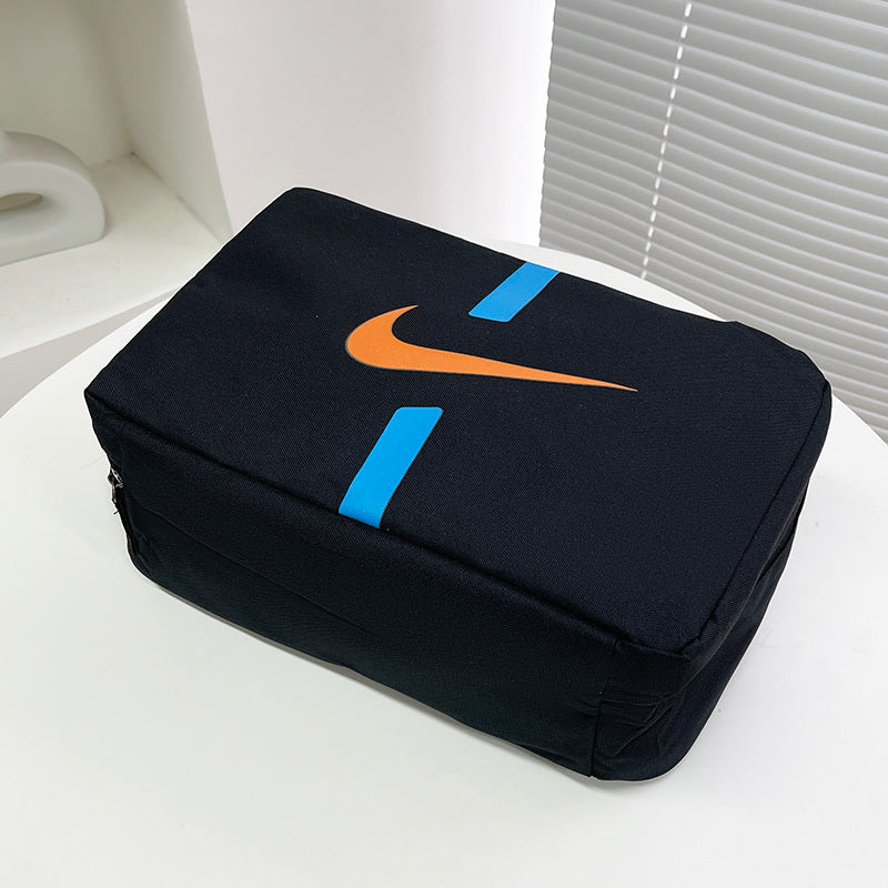 Mala Porta Chuteiras Nike em preto com logotipo laranja e detalhes azuis, ideal para transporte de chuteiras.