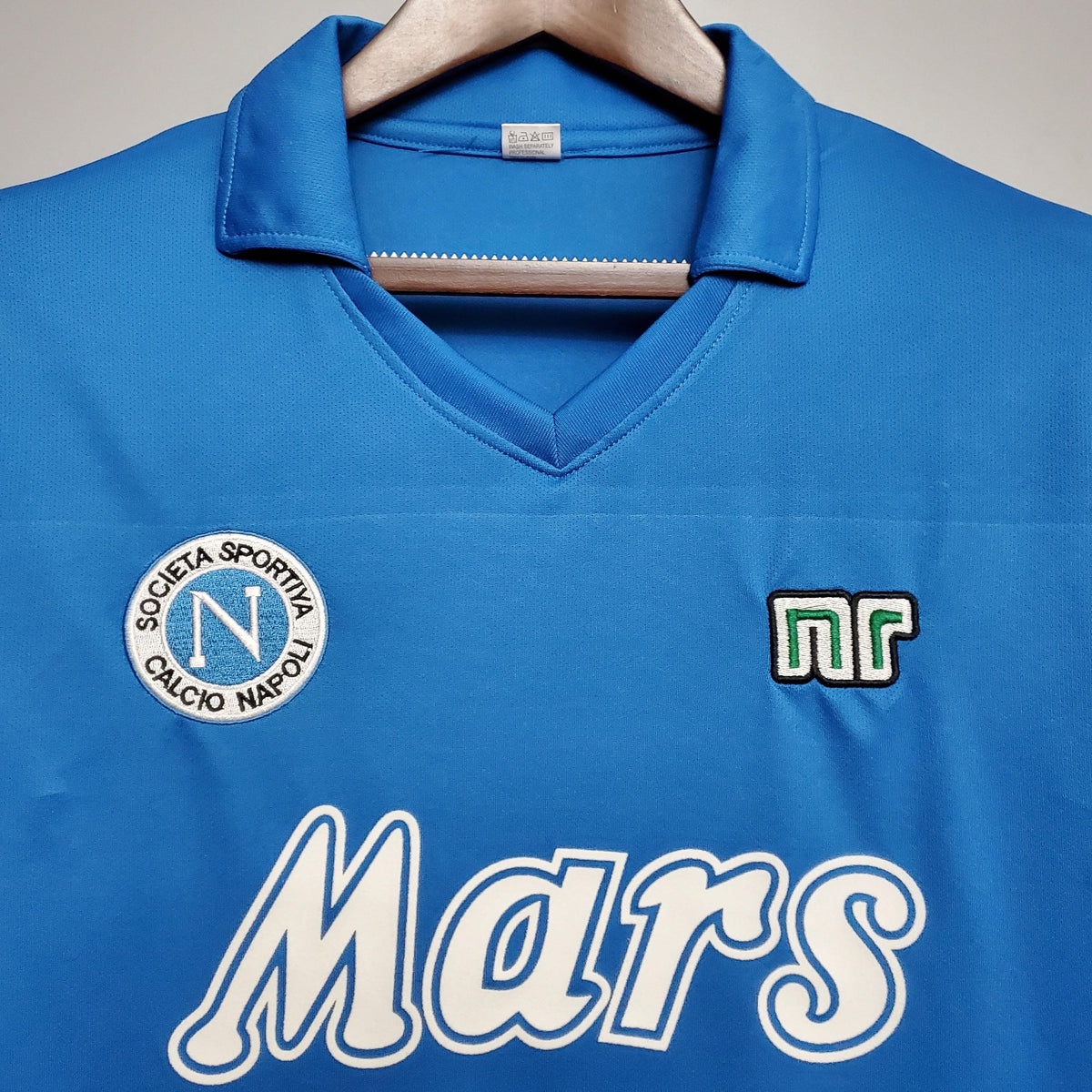 Camisolas Napoli Home 88/89 Retro, detalhe do uniforme azul com logo Mars e emblema da Società Sportiva Calcio Napoli.