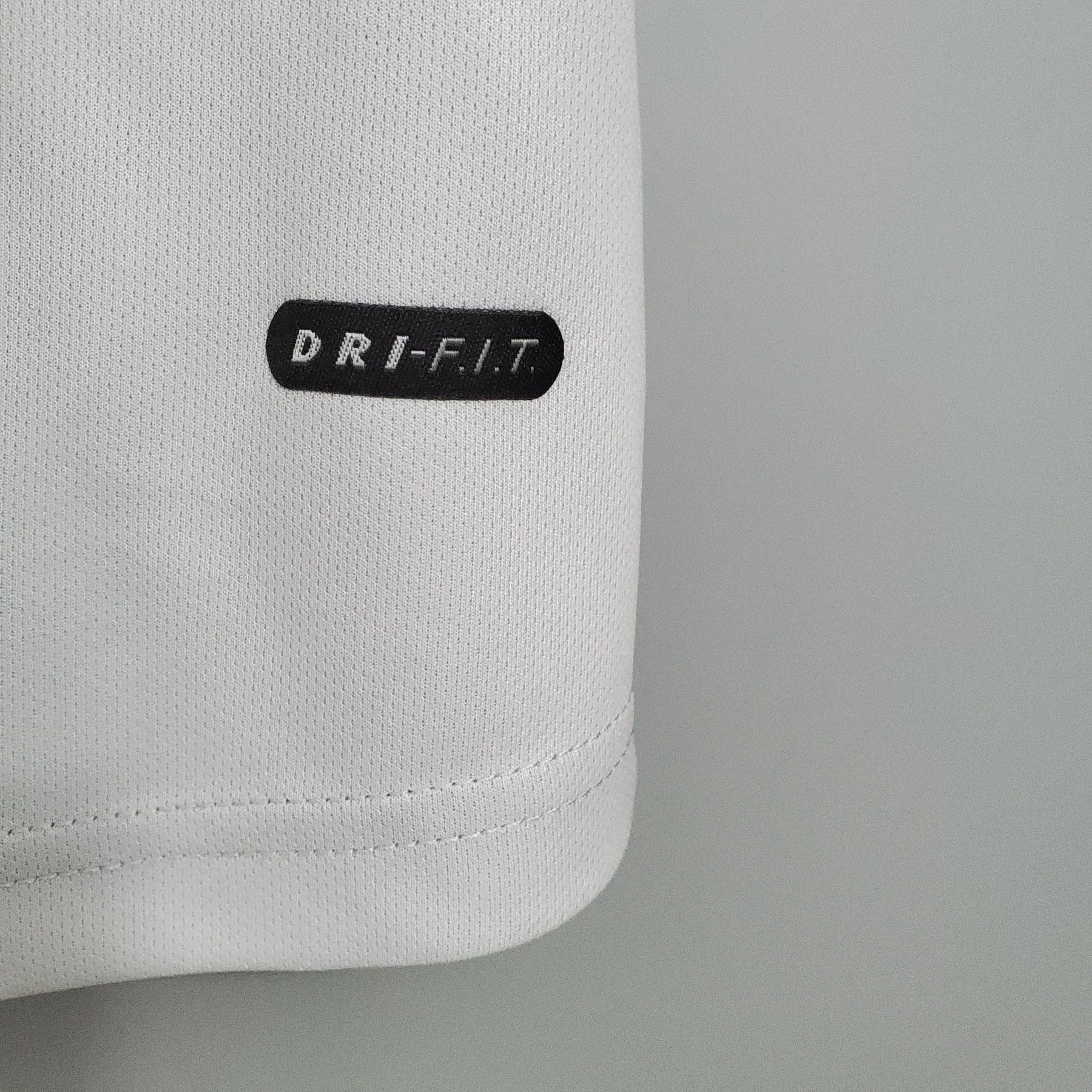 Emblema DRI-FIT em camisola PSG Away 01/02 Retro branca, destacando tecnologia de secagem rápida.