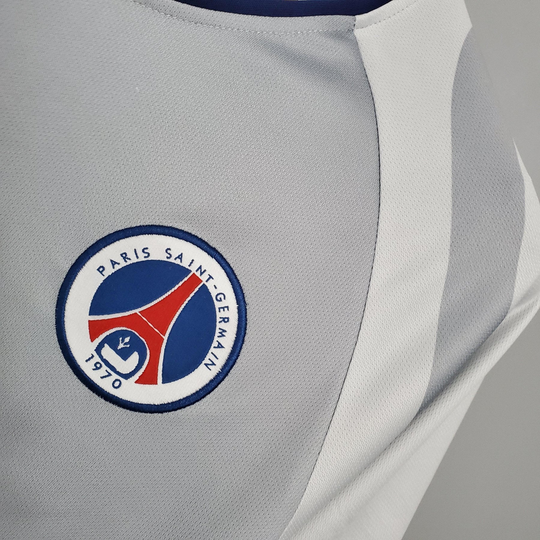 Emblema da camisola PSG Away 01/02 Retro branco Branco, destacando a tradição do Paris Saint-Germain.
