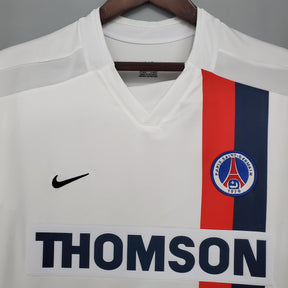 Camiseta PSG Away 02/03 Retro branco com detalhes em vermelho e azul, logo da Nike e patrocinador Thomson.