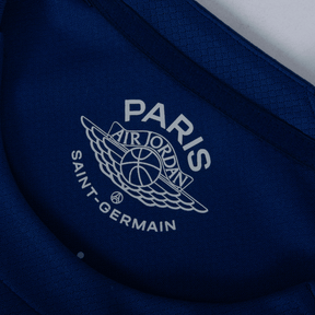 Logotipo da camiseta PSG fourth 24/25 azul marinho com Air Jordan e Paris Saint-Germain.