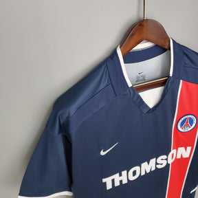 Camiseta PSG Home 02/03, estilizada com detalhes vermelhos e logo do time, disponível na Olympic Store.