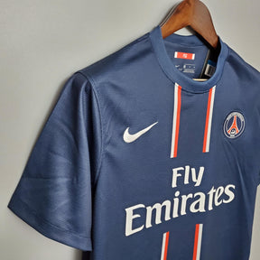 Camisa PSG Home 12/13 Retro Azul Marinho da OLYMPIC STORE com detalhes em branco e vermelho.