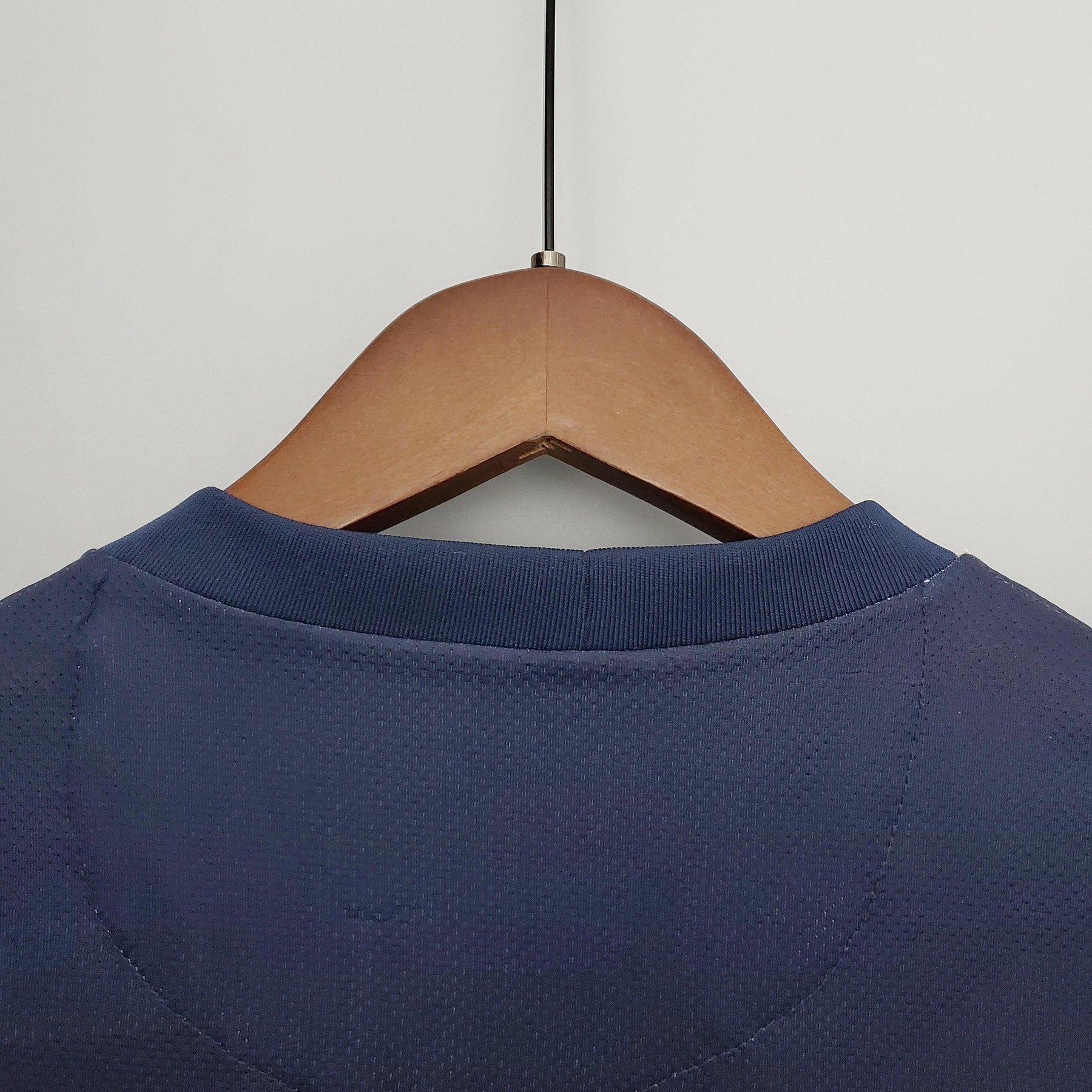 Detalhe da parte de trás da camisa PSG Home 13/14 Retro Azul Olympic pendurada em cabide.