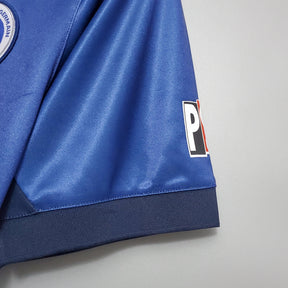 Detalhe da manga da camisola PSG Home 98/99 Retro Azul e Vermelho, mostrando textura e logo distintivo.