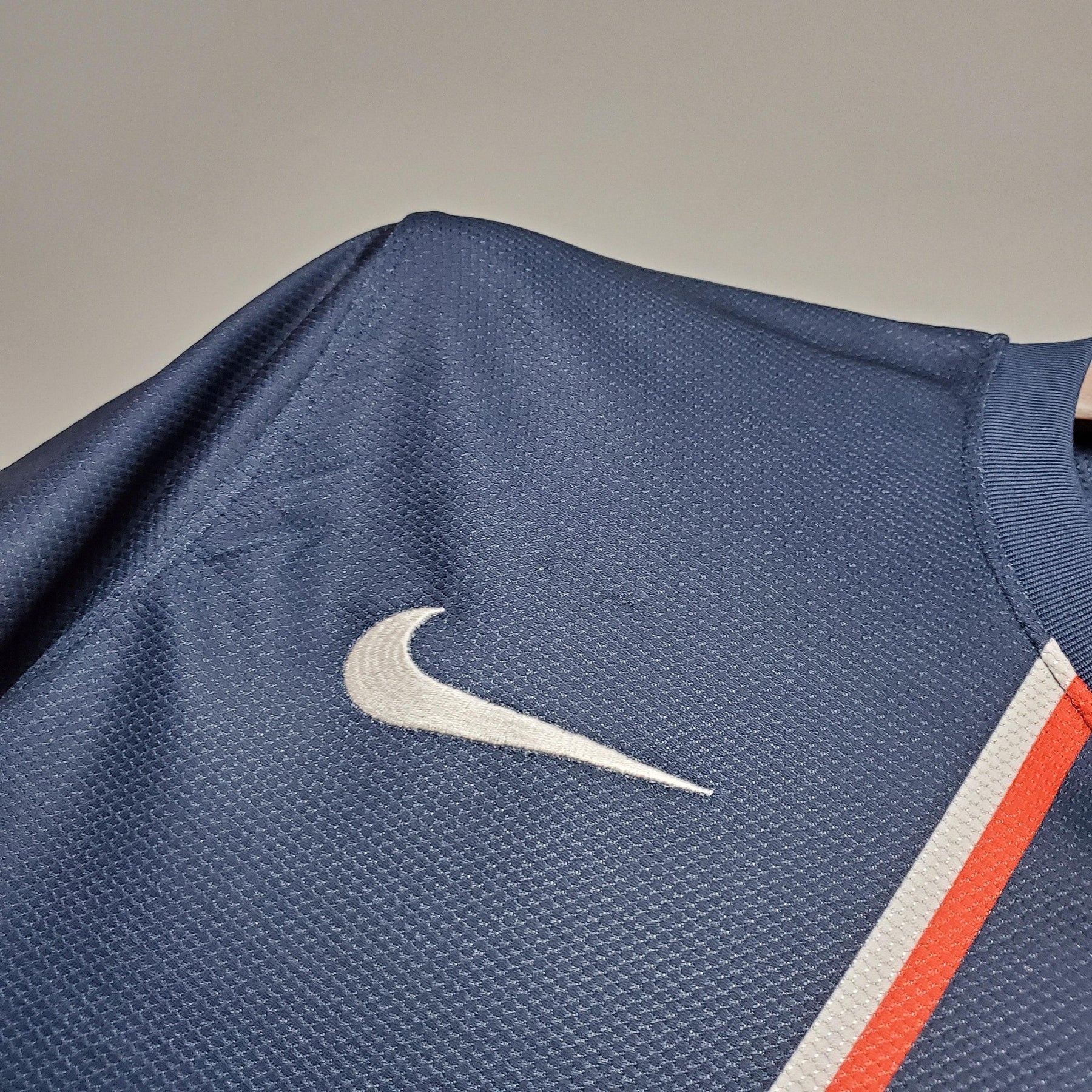 Detalhe da camisola PSG Home 12/13 Retro Azul Marinho com logo Nike em destaque.